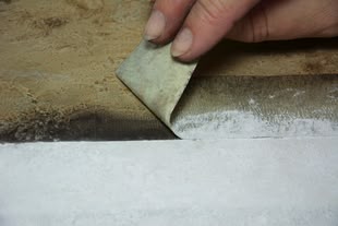 Ein Klebestreifen wird von einer Oberfläche abgezogen.