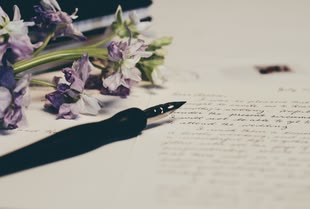 Photo by Debby Hudson on Unsplash Welke Blumen und ein Füller liegen auf einem beschriebenen Blatt Papier