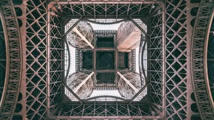 Touristenattraktionen interessant zu fotografieren ist gar nicht so leicht zu lernen (hier der Eiffelturm). Foto: Mika Baumeister/Unsplash. Eine Fotografie, in der der Eiffelturm von unten dargestellt wird.