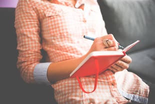 Creative Writing, kreatives Schreiben, Kreativurlaub, Kreativreise, kreative Auszeit, Foto: Pixabay Eine Frau sitzt auf einem Sofa und schreibt in ein Notizbuch