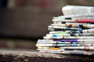 mehrere gefaltete Zeitungen liegen aufeinander