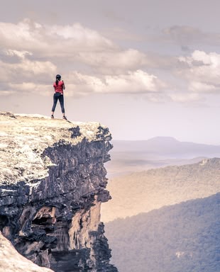 Mit aufregenden Fotoprojekten können Sie aus Ihrem Alltag ausbrechen! Foto: StockSnap/Pixabay License. Eine Frau steht auf einem Felsen inmitten eines Gebirges.