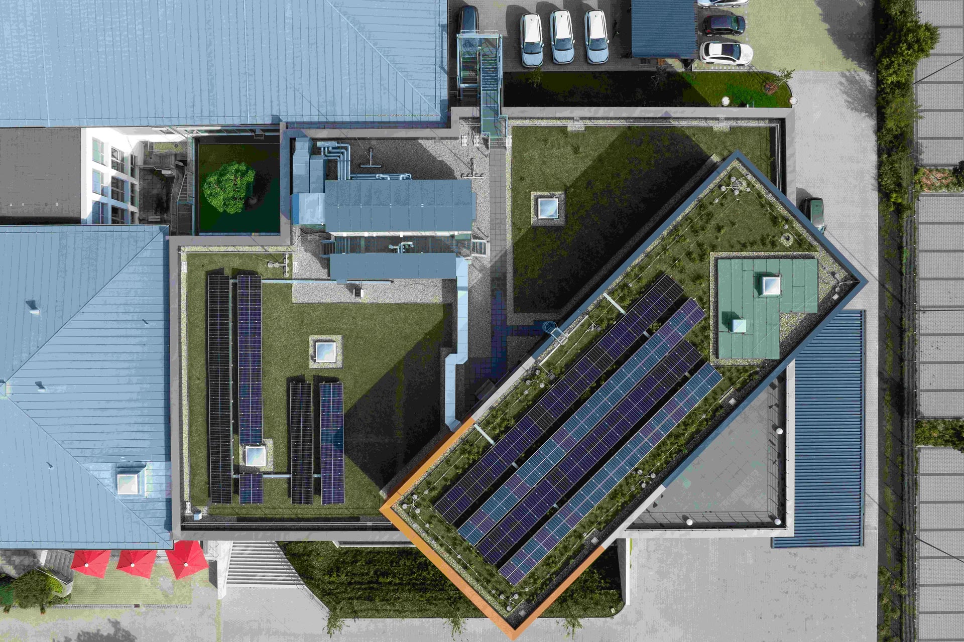 Foto von einem modernen Gebäude mit Photovoltaik-Anlage auf dem Dach aus der Vogelperspektive