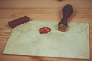 Der Stempelabdruck beim Embossing erinnert an ein Relief. Foto: Pixabay Auf einem Briefumschlag liegt ein Siegelstempel.