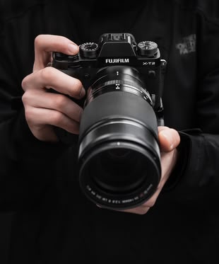 Was Sie über Ihre Kamera wissen sollten – vor der Reise und vor dem Kauf. Foto: Markus Lompa/Unsplash. Eine Person hält eine Kamera in ihren Händen.