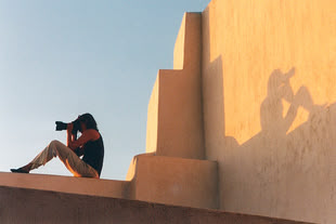 Fotografieren lernen im Fotokurs mit Jutta Engelage. Foto: Jutta Engelage Eine Fotografie von Jutta Engelage, in der eine Frau abgebildet wird, die auf einem Gemäuer sitzt.