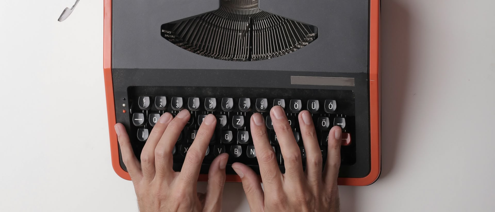 2 Hände auf der Tastatur einer mechanischen Schreibmaschine