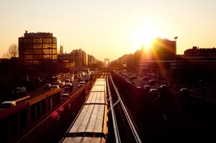 Die richtige Zeit zum Fotografieren – Reisefotografie lernen im Fotokurs. Foto: Geoffrey Arduini/Unsplash. Fotografie einer Straßenbahn, die durch eine Stadt fährt.