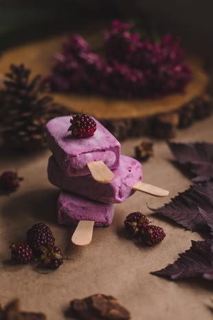 Food fotografieren lernen im Fotokurs oder Fotoworkshop. Foto: Pablo Merchan Montes/Unsplash. Drei Eis am Stil werden auf einer dekorierten Oberfläche abgebildet.
