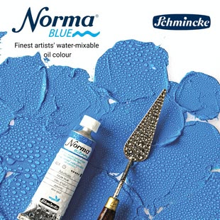Schmincke NORMA Blue. Foto: Schmincke Eine Tube mit blauer Norma Blue Farbe von Schmincke neben einem Spachtel auf blau gemaltem Hintergrund