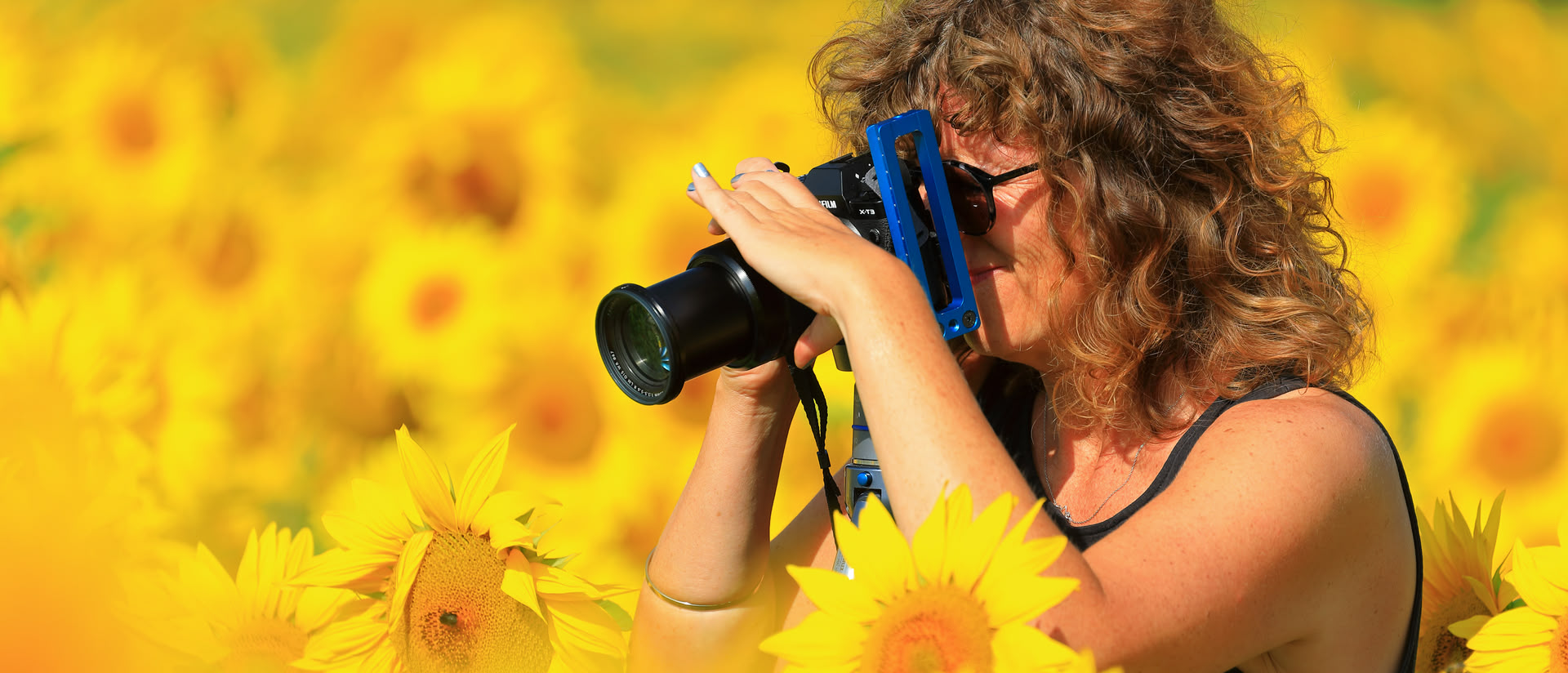 Frau mit Kamera in Sonnenblumen-Feld