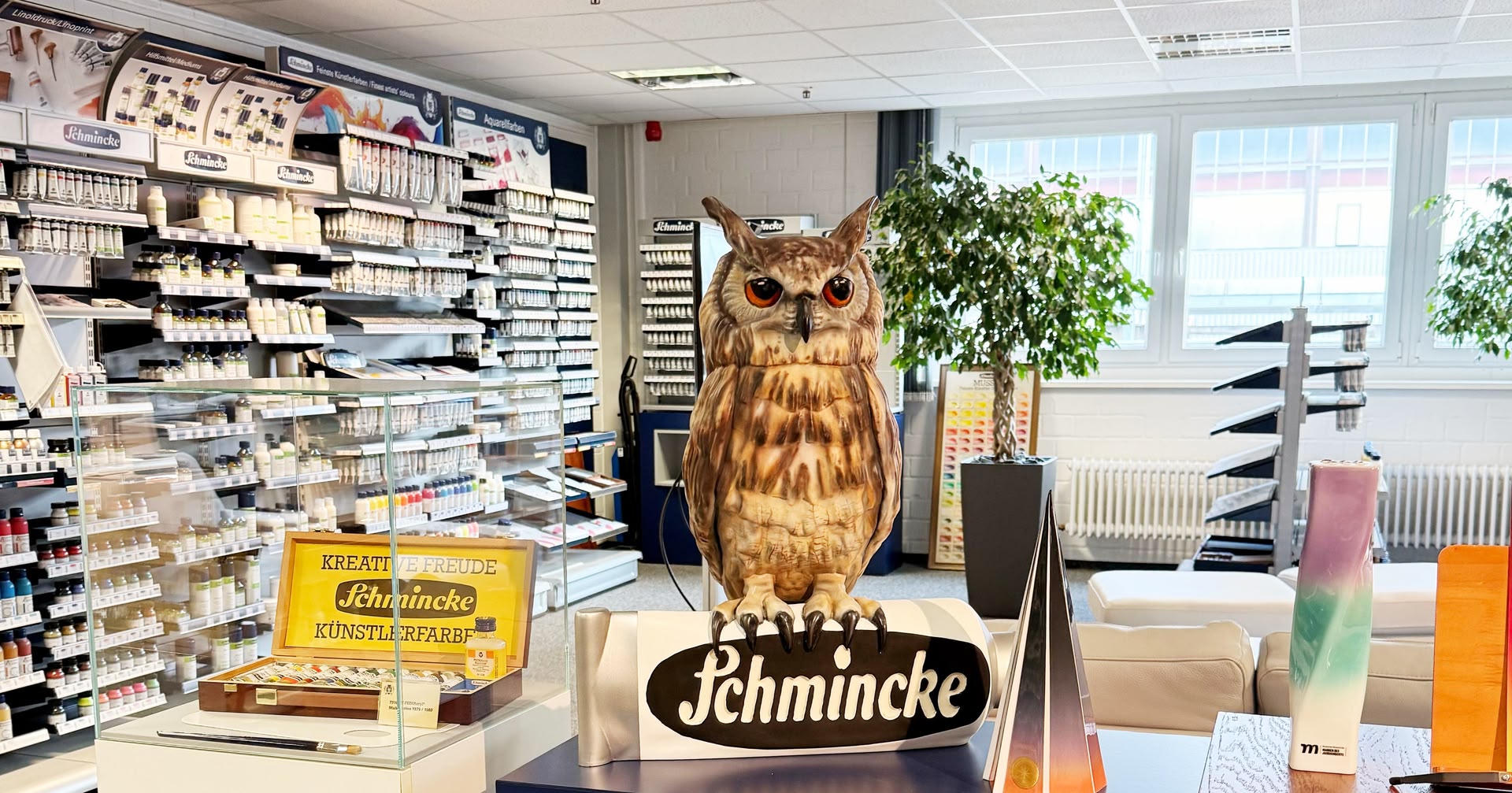 Im kleinen Museum des Schmincke-Werks sitzt eine Eule auf einer überdimensionierten Schmincke-Farbtube