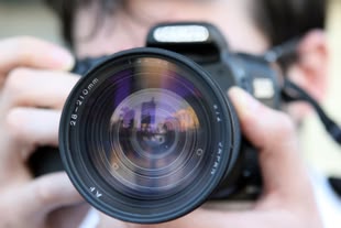 Eine Kamera wird in Richtung der fotografierenden Person gehalten.