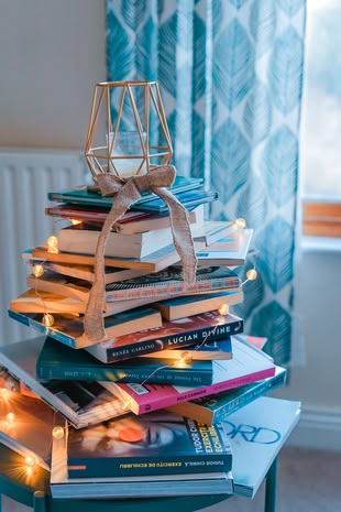 Creative Writing / Kreatives Schreiben. Schreiben lernen / malen lernen. Foto: Toa Heftiba / Unsplash Ein Stapel mit Büchern, ganz oben steht eine Kerze darauf.