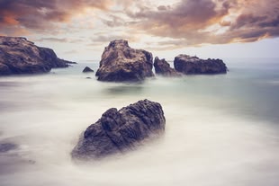 In der Fotografie werden mit Nebel umhüllte Felsen dargestellt.