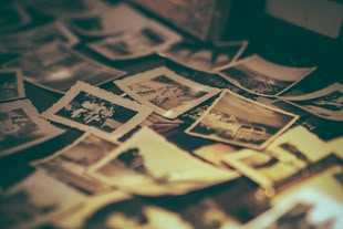 Alte Fotos können hervorragend in Collagen eingearbeitet werden. Foto: Igor Ovsyannykov/Pixabay License. Eine Oberfläche ist mit kleinen Fotografien bedeckt.