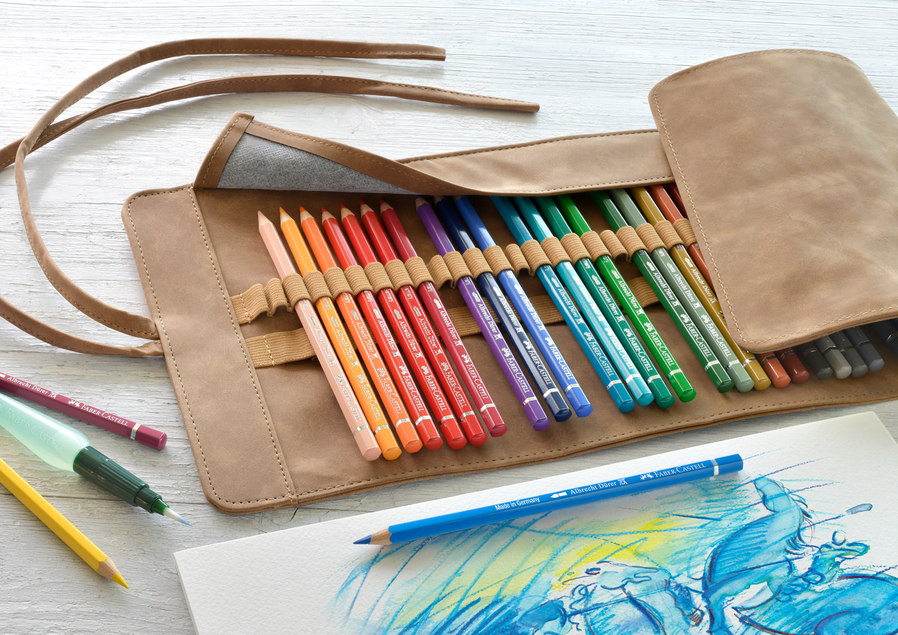 Bunte Farbstifte von Faber-Castell nach Farben geordnet in einer Stifterolle aus Leder