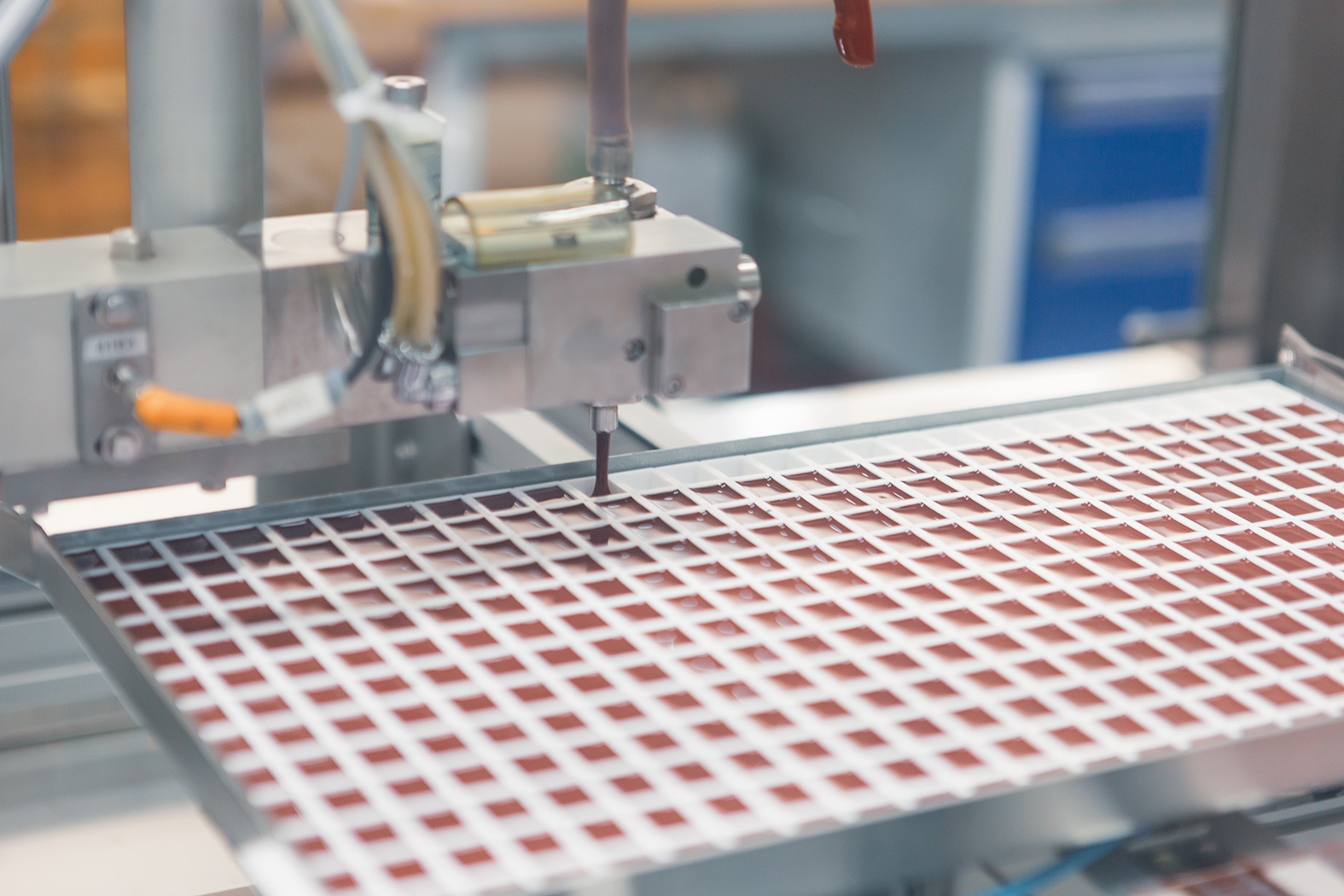 Farbe wird durch eine Art Sieb gefüllt in der Produktion im Schmincke Werk.