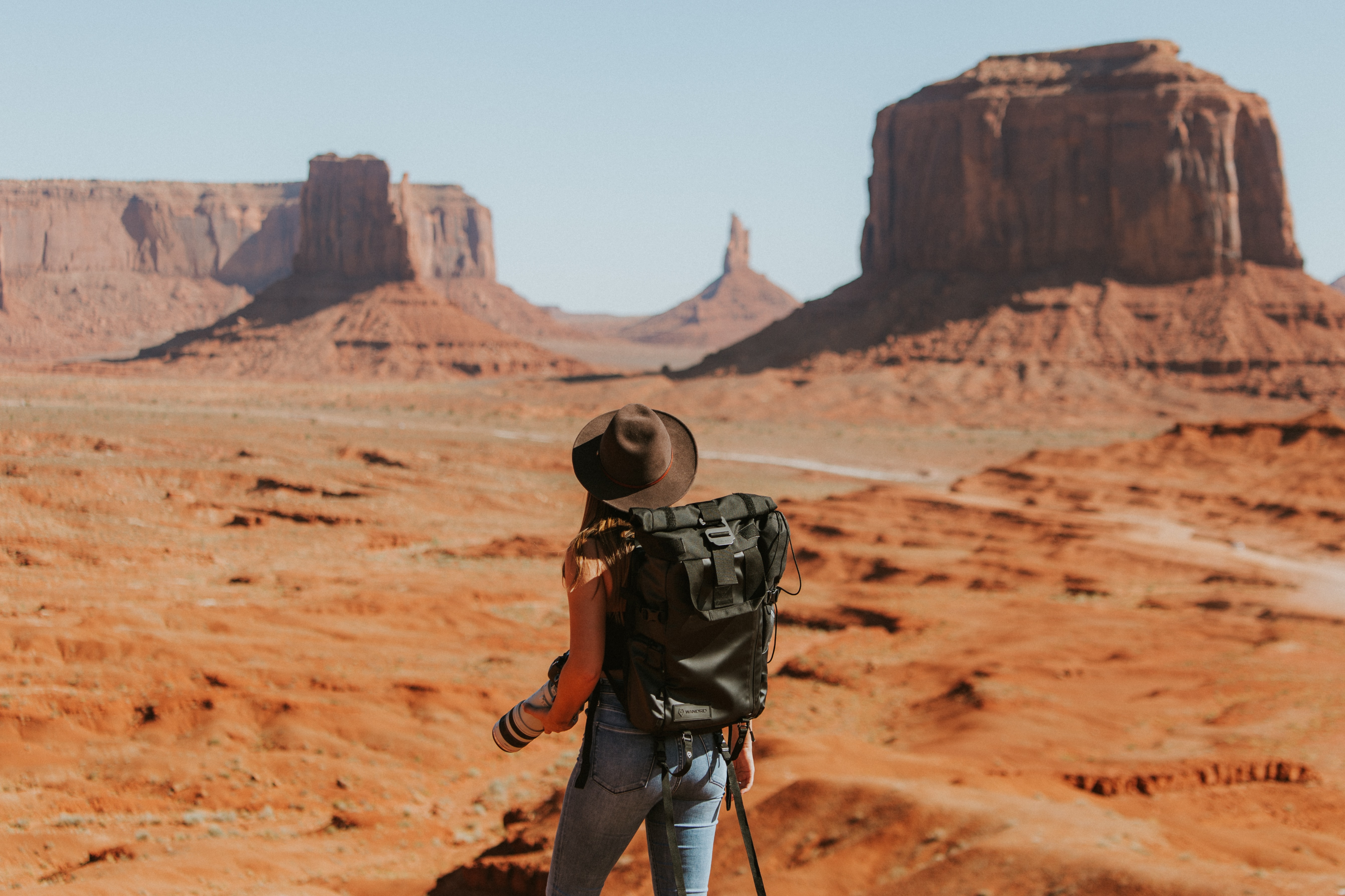 Fotografin am Grand Canyon Fotografin steht am Rand des Grand Canyon und blickt in die beeindruckende Schlucht mit Sonnenhut und Kamera in der Hand